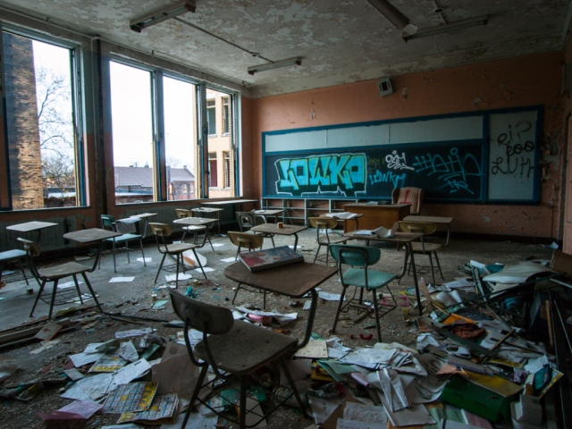 abandoned classroom with desks books and all left behind