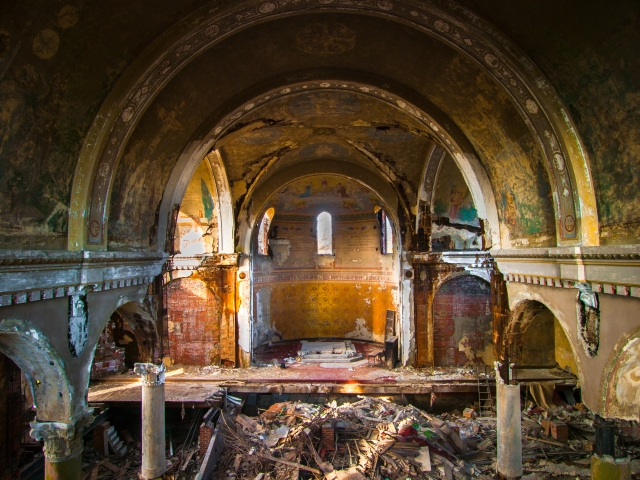 arches and other crumbling architecture inside abandoned church