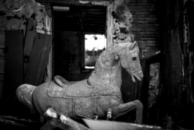 creepy rocking horse inside abandoned house