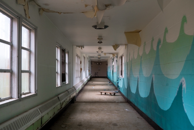 wave paintings in hallway inside abandoned hospital