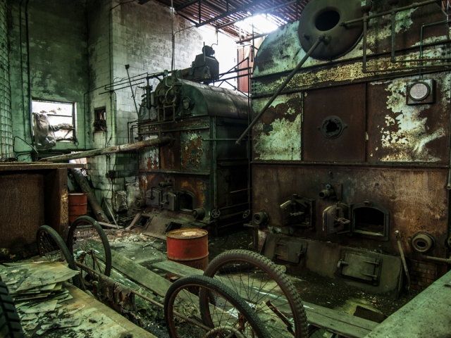 old rusted machinery and generators in abandoned greenhouse