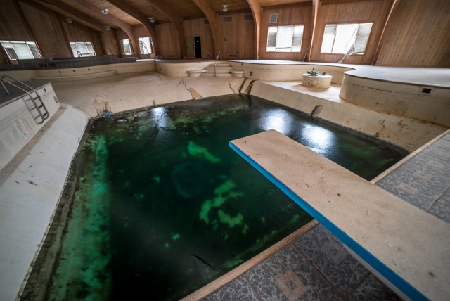 frozen pool and diving board inside Mike Tyson's Abandoned Mansion
